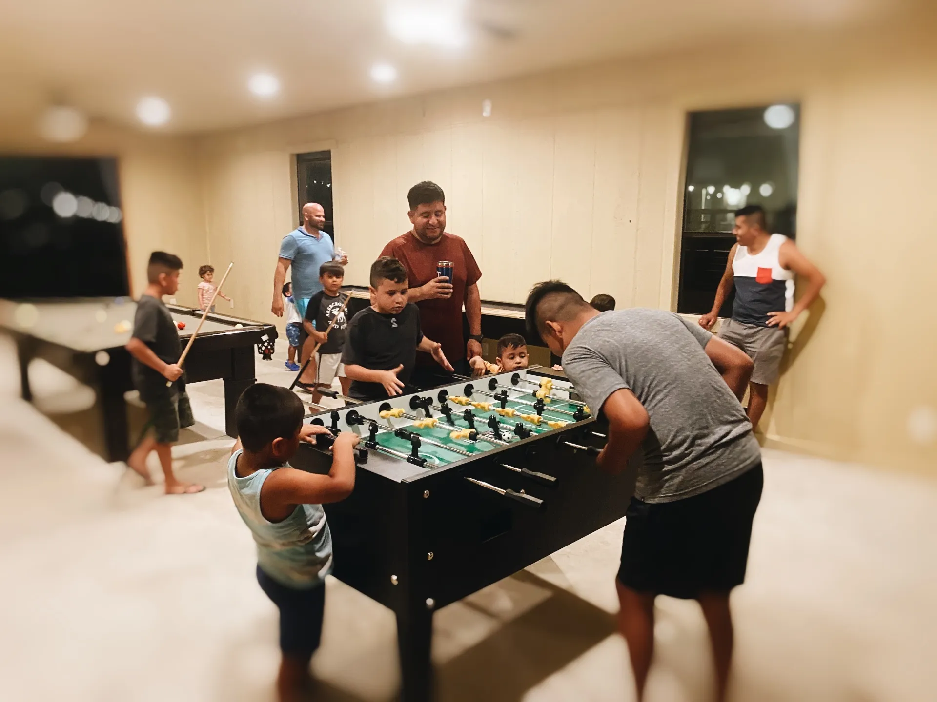 Family playing foosball in game room