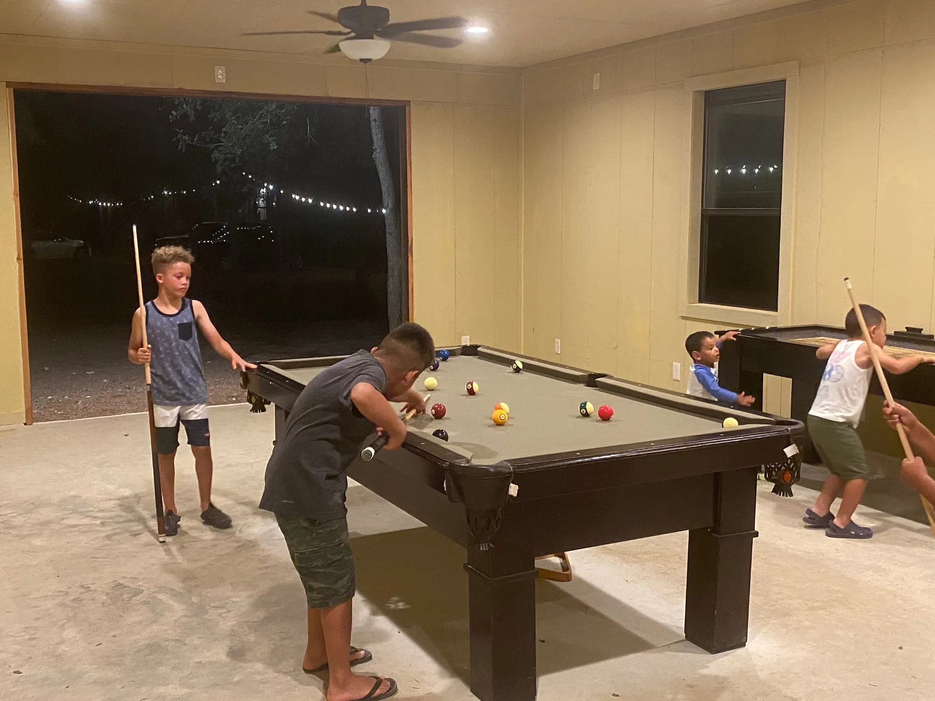 Kids playing pool in the game room