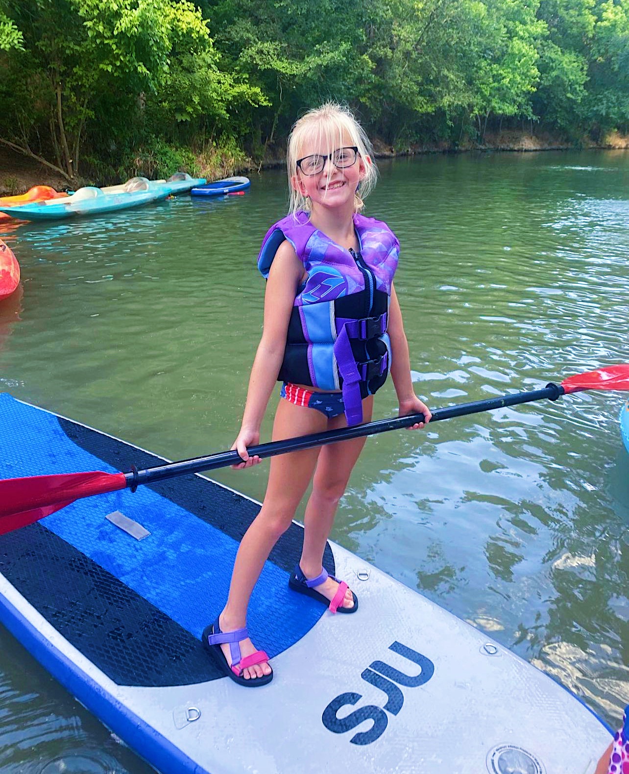 Kids playing on paddleboard in the creek