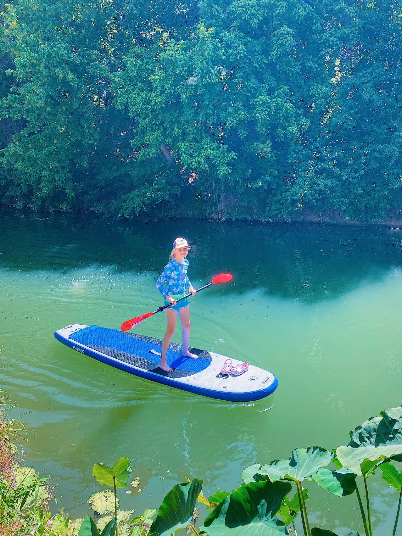 Girl paddleboarding on the creek