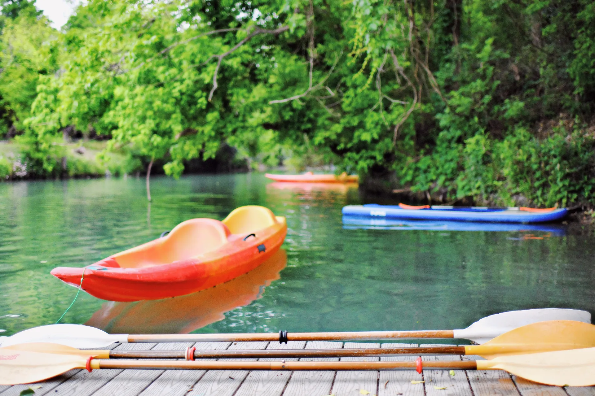Calm spring-fed Geronimo Creek with kayaks at the dock near New Braunfels