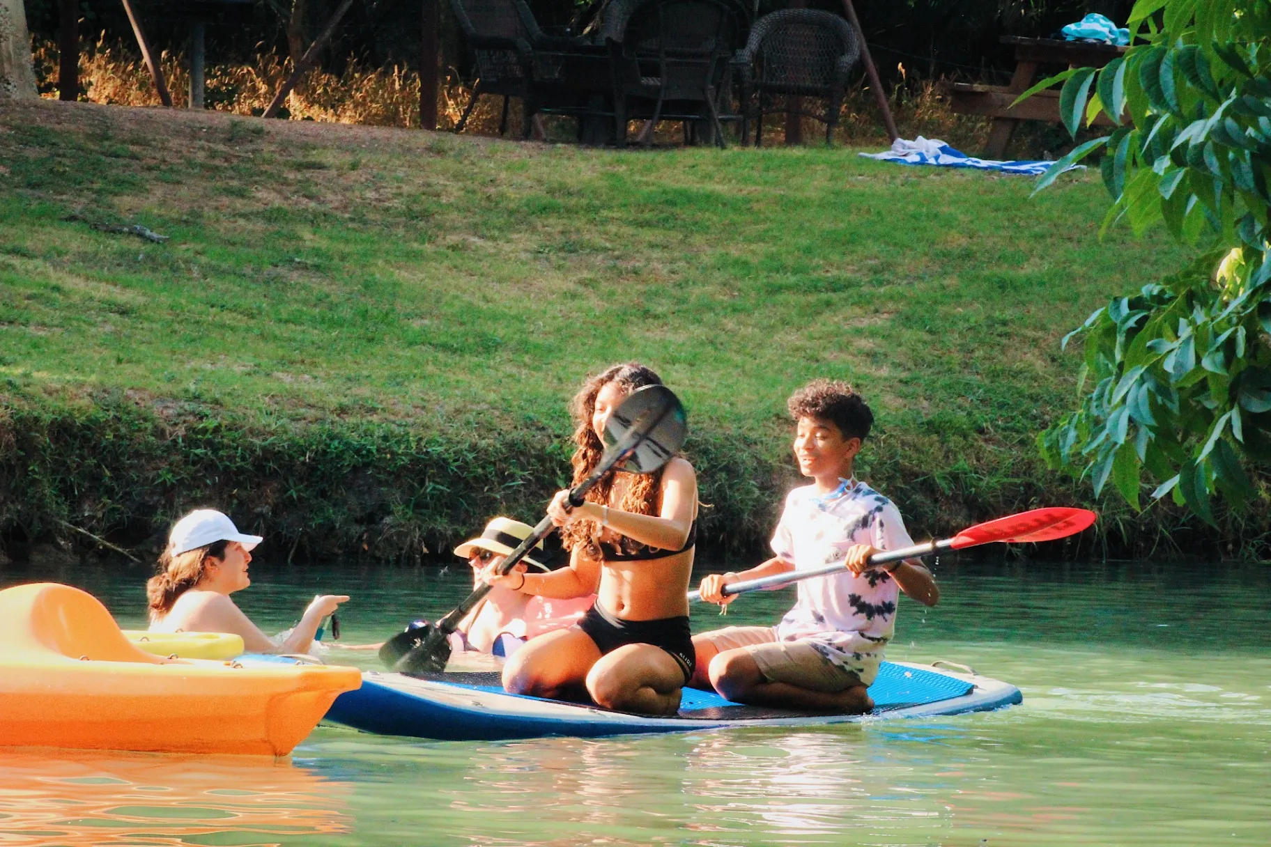 Teens paddleboarding on Geronimo Creek